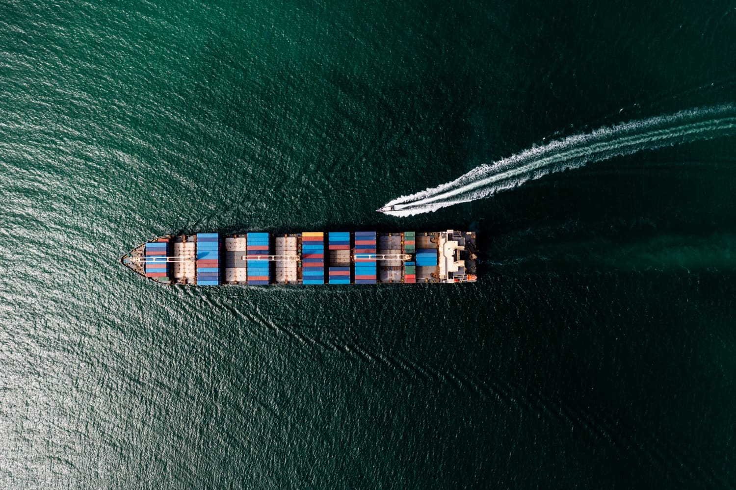 Large ship from above with small ship by the side